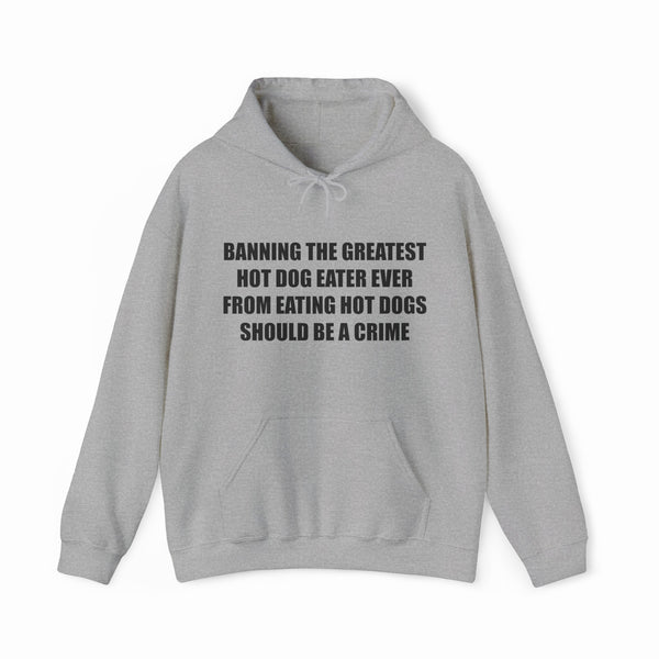 The “Banning The Greatest Hot Dog Eater Ever From Eating Hot Dogs Should Be A Crime Hoodie” features black text on gray—perfect for fans of funny hot dog shirts or anyone who loves humorous, bold statement apparel.