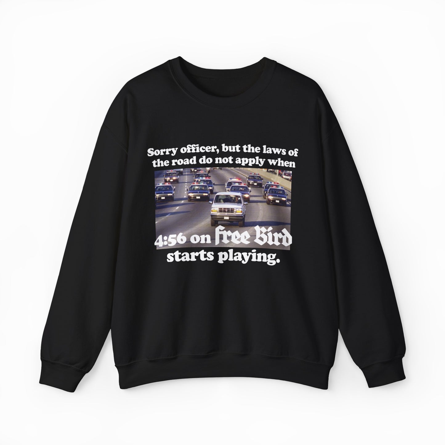 The O.J. Simpson Free Bird Crewneck features a black design with cars on a highway and the text: "Sorry officer, but the laws of the road do not apply when 4:56 on Free Bird starts playing." Perfect for fans of funny shirts and classic rock vibes.
