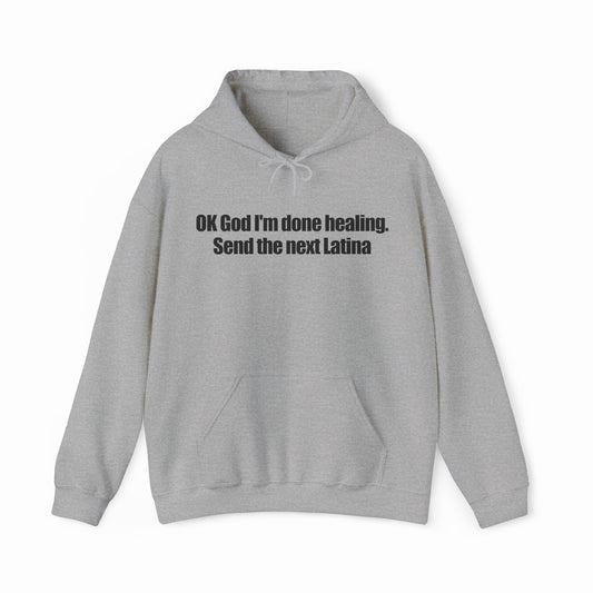 A light gray OK God I'm Done Healing. Send The Next Latina hoodie features bold black text across the chest—perfect for anyone wanting a standout Latina hoodie with attitude.