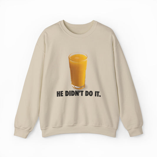 The He Didn't Do It Crewneck is a beige sweatshirt with a glass of orange juice above bold black text—ideal for fans of funny shirts or anyone seeking unique Illegal Shirts with a playful twist.