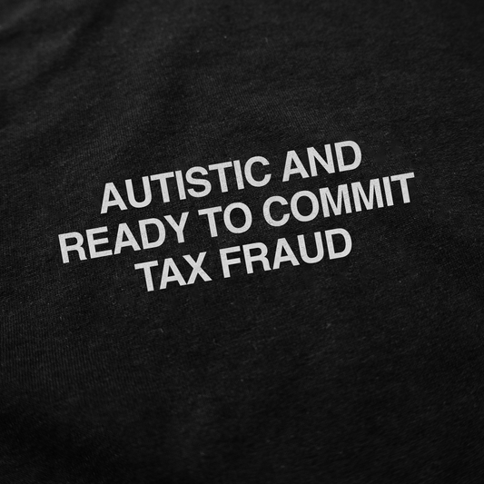 White text on black fabric reads: AUTISTIC AND READY TO COMMIT TAX FRAUD. The Autistic And Ready To Commit Tax Fraud T-Shirt is a bold, funny choice for anyone who loves edgy shirts.