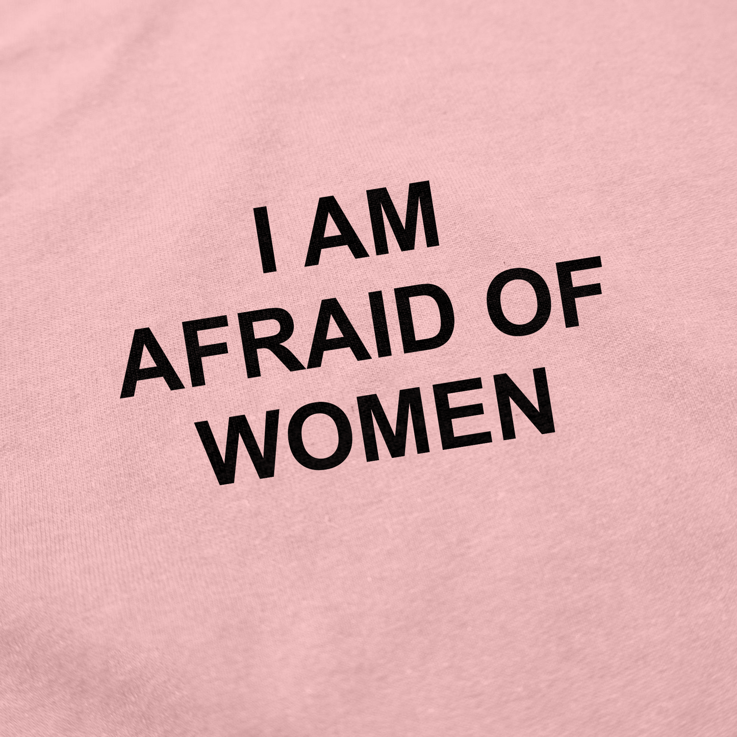The I Am Afraid Of Women T-Shirt is a pink, ethically made cotton shirt with bold black text that playfully states "I AM AFRAID OF WOMEN"—a humorous choice for anyone looking to make a statement.