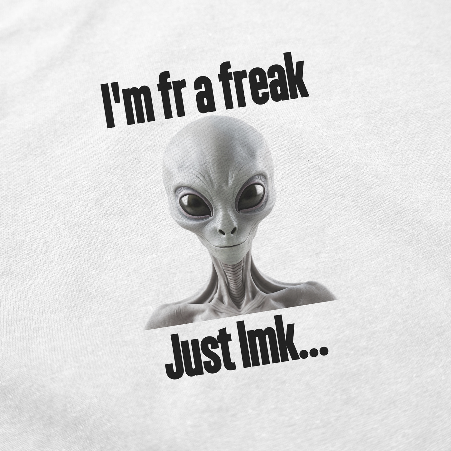 The I'm FR A Freak Just LMK... T-Shirt features a gray alien with big black eyes between the phrases "I'm fr a freak" and "Just lmk...", all printed on 100% cotton for a unique look.