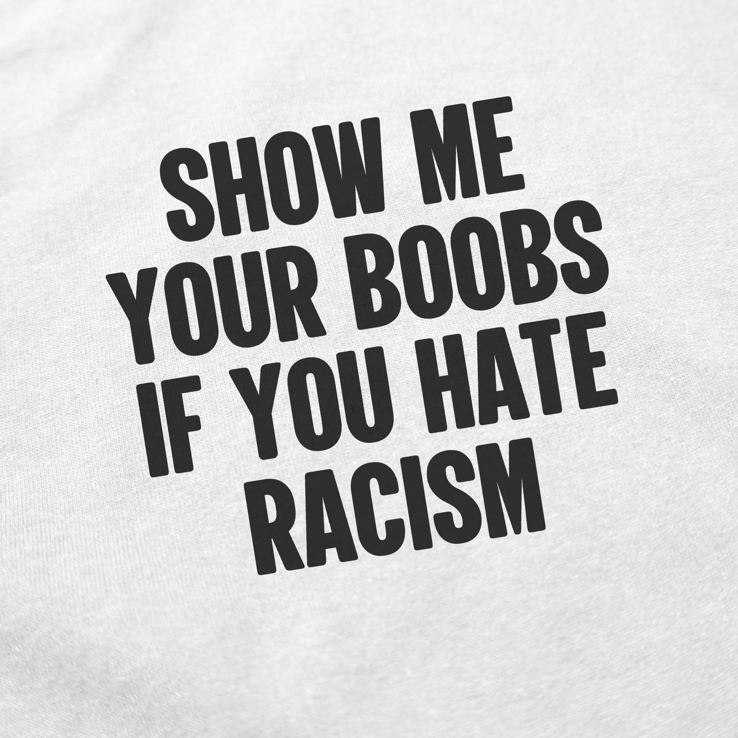 Black text on white fabric reads, SHOW ME YOUR BOOBS IF YOU HATE RACISM. The Show Me Your Boobs If You Hate Racism T-Shirt is ethically made and makes a bold anti-racism statement.
