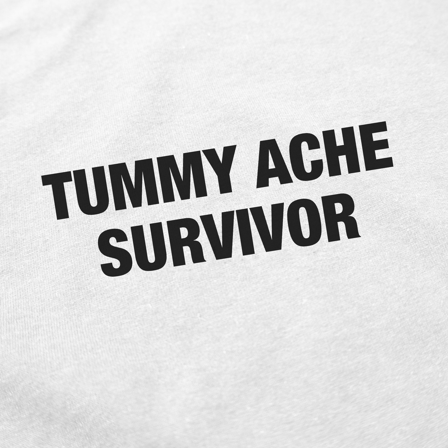 The Tummy Ache Survivor T-Shirt features bold black text on white cotton—perfect for anyone who loves funny shirts with attitude.