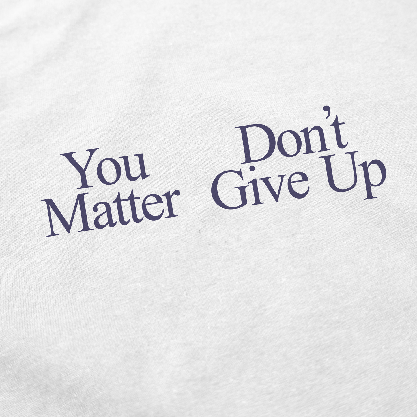 Close-up of white fabric with black text reading "You Matter Don't Give Up"—a motivational and encouraging message, unlike the You Don’t Matter Give Up T-Shirt.