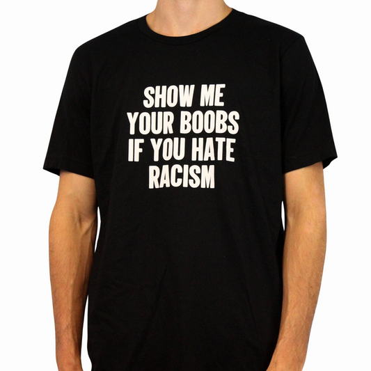 Wearing the Show Me Your Boobs If You Hate Racism T-Shirt, cropped to show only their lower face and torso, someone displays this bold black tee with striking white text—an ethically made garment that makes a strong anti-racism statement.