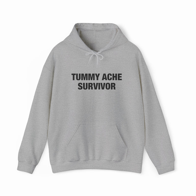 The Tummy Ache Survivor Hoodie is a light gray cotton-polyester sweatshirt with a front pocket, drawstrings, and bold black "TUMMY ACHE SURVIVOR" text—perfect for Illegal Shirts fans.