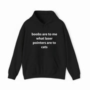 The Boobs Are To Me What Laser Pointers Are To Cats Hoodie features bold white text on black, offering a funny statement piece from Illegal Shirts sure to spark laughs.