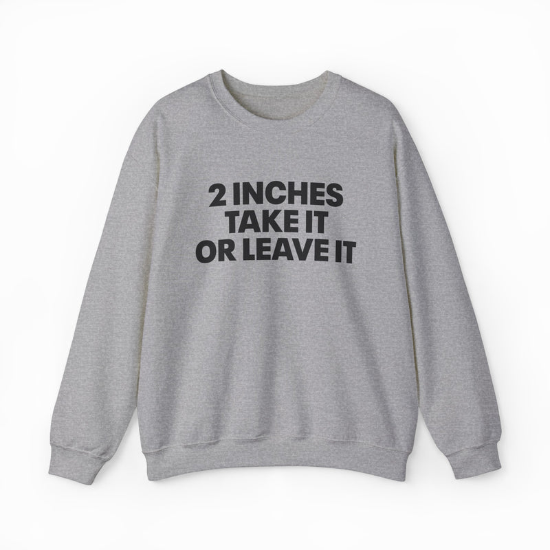 The 2 Inches Take It Or Leave It Crewneck in gray features bold black text on the front and is laid flat on a white background—perfect for anyone who enjoys funny shirts and wants to add humor to their style.