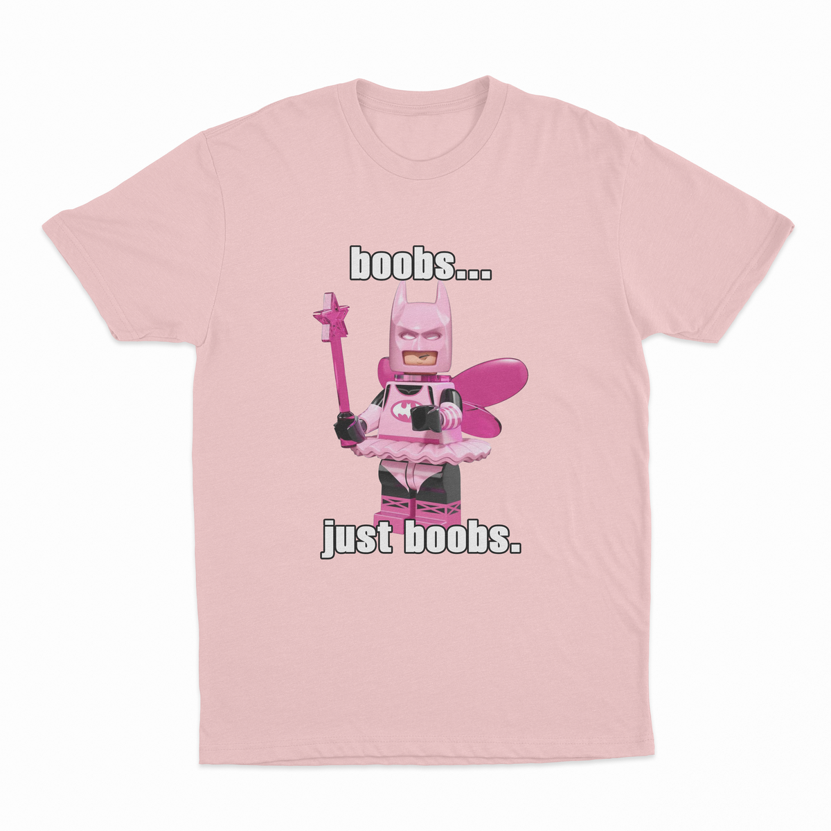 The "Boobs... Just Boobs. T-Shirt" is a pink tee with a LEGO-style Batman in a pink fairy costume, wings, and wand. Features bold text above and below the figure. Ideal for fans of humorous statement shirts!.