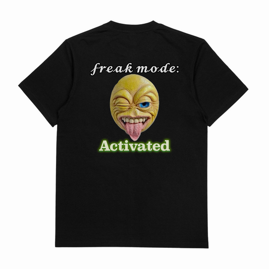 The Freak Mode Activated T-Shirt (Backprint) is made from ethically grown black cotton, highlights "freak mode: Activated" with a winking emoji and green "Activated," and offers premium comfort at 175 GSM.