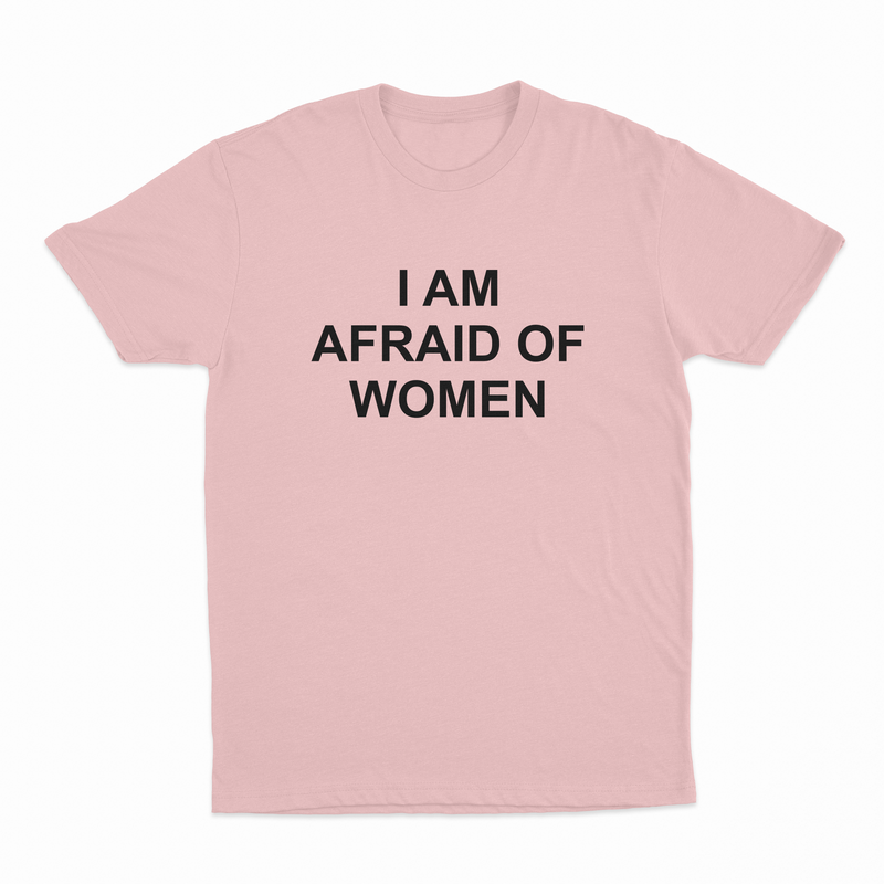 The I Am Afraid Of Women T-Shirt is light pink, made from 175 GSM ethically grown cotton, and features bold black "I AM AFRAID OF WOMEN" text printed in capitals on the front.