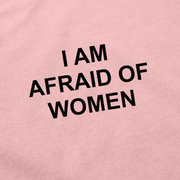 The I Am Afraid Of Women T-Shirt is a pink, ethically made cotton shirt with bold black text that playfully states "I AM AFRAID OF WOMEN"—a humorous choice for anyone looking to make a statement.