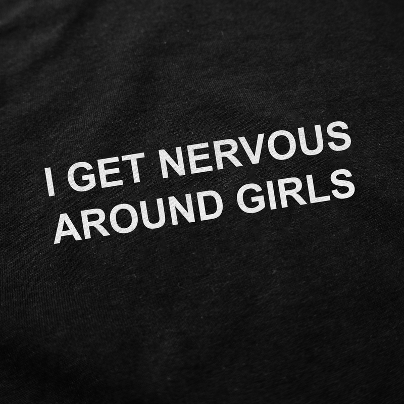 Close-up of the I Get Nervous Around Girls T-Shirt in black cotton with white text. Crafted ethically at 175 GSM for a soft feel.
