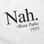 The Nah. T-Shirt features black "Nah. -Rosa Parks 1955" text on white fabric, honoring Rosa Parks' 1955 stand. Made from ethically grown cotton, it offers a comfortable and conscious choice.