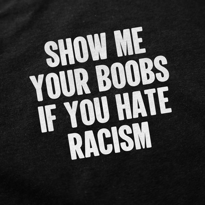 The Show Me Your Boobs If You Hate Racism T-Shirt features bold white text on black fabric, making a strong anti-racism statement with attitude and purpose. Ethically made for those who want their voice to be seen.