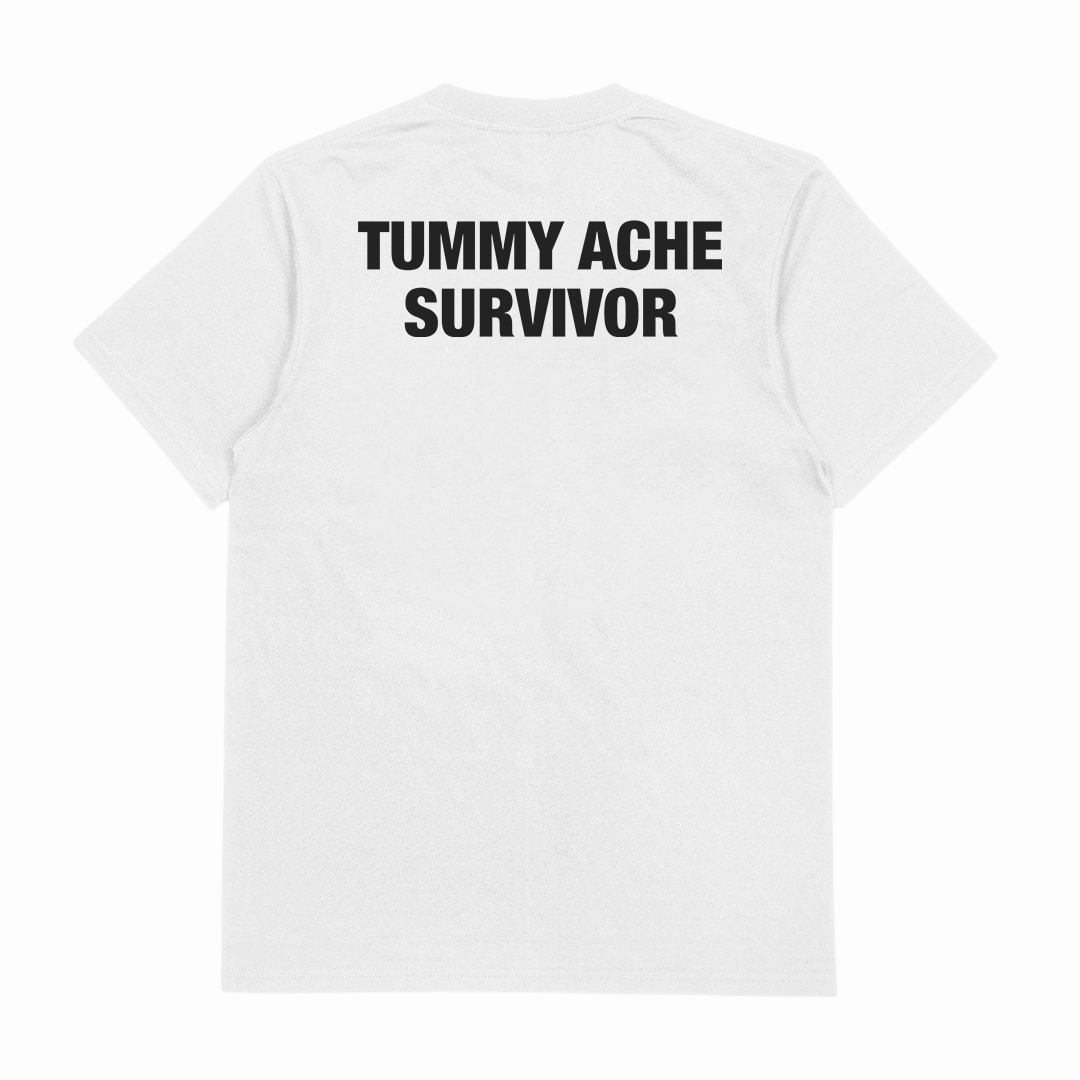 The Tummy Ache Survivor T-Shirt (Backprint) is a plain white tee made from 100% cotton, featuring "TUMMY ACHE SURVIVOR" boldly printed on the upper back.