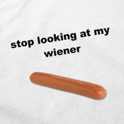 The Stop Looking At My Wiener T-Shirt features a hot dog image and bold black text reading "stop looking at my wiener"—a playful design on white cotton.
