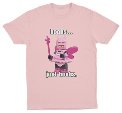 The "Boobs... Just Boobs. T-Shirt" is a pink tee with a LEGO-style Batman in a pink fairy costume, wings, and wand. Features bold text above and below the figure. Ideal for fans of humorous statement shirts!.