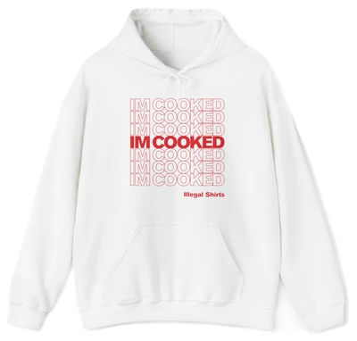 The I'm Cooked Hoodie is white, with bold red "I’m Cooked" text in a grid, centered and bolded. “Illegal Shirts” appears below in smaller red letters. Made from medium-heavy fabric with a front pocket and drawstring hood.