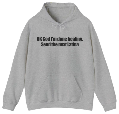 A light gray OK God I'm Done Healing. Send The Next Latina hoodie features bold black text across the chest—perfect for anyone wanting a standout Latina hoodie with attitude.
