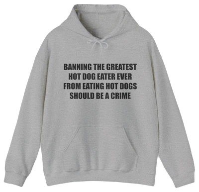 The “Banning The Greatest Hot Dog Eater Ever From Eating Hot Dogs Should Be A Crime Hoodie” features black text on gray—perfect for fans of funny hot dog shirts or anyone who loves humorous, bold statement apparel.