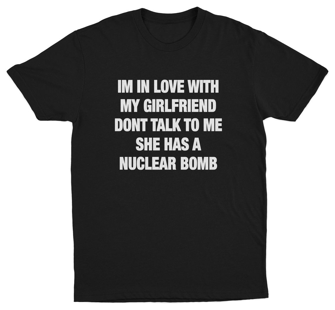 Black crew neck t-shirt with white text that reads: 'I'M IN LOVE WITH MY GIRLFRIEND DON'T TALK TO ME SHE HAS A NUCLEAR BOMB'.