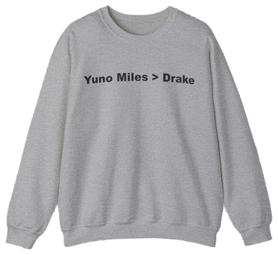 The Yuno Miles > Drake Crewneck is a gray sweatshirt featuring "Yuno Miles > Drake" in bold black text—a perfect pick for fans of funny shirts and the iconic crewneck style.