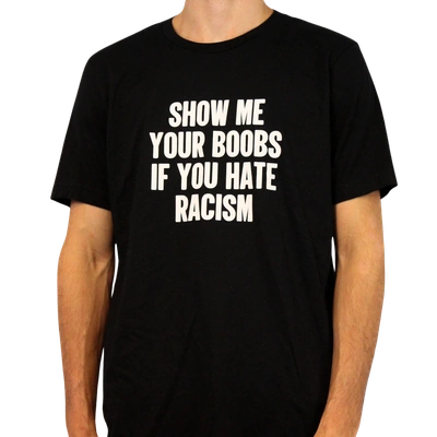 Wearing the Show Me Your Boobs If You Hate Racism T-Shirt, cropped to show only their lower face and torso, someone displays this bold black tee with striking white text—an ethically made garment that makes a strong anti-racism statement.