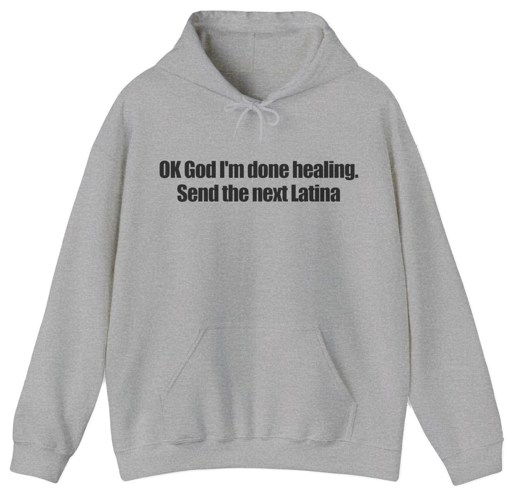 A light gray OK God I'm Done Healing. Send The Next Latina hoodie features bold black text across the chest—perfect for anyone wanting a standout Latina hoodie with attitude.